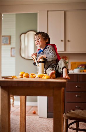 spremiagrumi a mano - Happy young boy juicing oranges for breakfast. Fotografie stock - Premium Royalty-Free, Codice: 6128-08738121