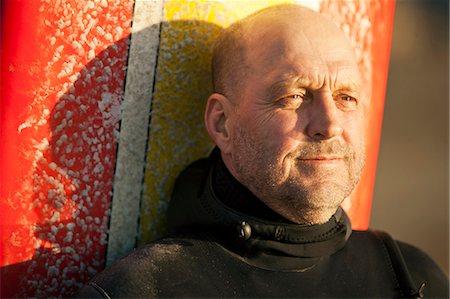 surf boards - Content mid adult man standing with his surfboard in the sunshine. Stock Photo - Premium Royalty-Free, Code: 6128-08738248