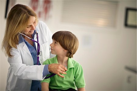 female doctor with male patient - Doctor using a stethoscope to listen to a young boy's heartbeat. Stock Photo - Premium Royalty-Free, Code: 6128-08738280