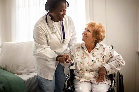 simsearch:6128-08738204,k - Smiling female doctor having a conversation with an elderly female patient sitting in a wheelchair. Stock Photo - Premium Royalty-Free, Code: 6128-08738206