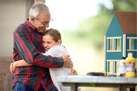 dollhouse - Smiling senior man embracing hi8s young granddaughter. Photographie de stock - Premium Libres de Droits, Code: 6128-08738238
