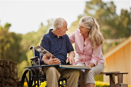 Smiling mature woman looking through a photo album with her senior husband. Foto de stock - Sin royalties Premium, Código: 6128-08738391