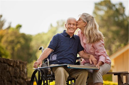 Smiling mature woman looking through a photo album with her senior husband. Stock Photo - Premium Royalty-Free, Code: 6128-08738392