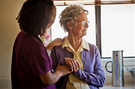 schlechte neuigkeiten - Young nurse comforting a grieving senior woman. Foto de stock - Sin royalties Premium, Código: 6128-08738397