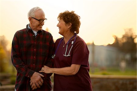 sick outside - Smiling nurse comforting an elderly patient. Stock Photo - Premium Royalty-Free, Code: 6128-08738300