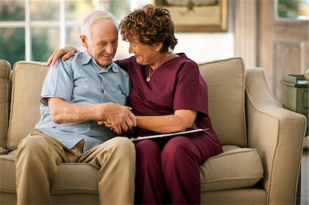 simsearch:6128-08738394,k - Smiling mature nurse comforting an elderly patient. Fotografie stock - Premium Royalty-Free, Codice: 6128-08738305