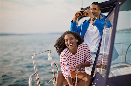simsearch:6128-08737749,k - Happy young couple having fun with binoculars while sailing. Foto de stock - Sin royalties Premium, Código: 6128-08738485