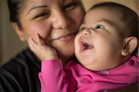 simsearch:6128-08728378,k - Portrait of a smiling baby girl being held by her mother. Foto de stock - Sin royalties Premium, Código: 6128-08738547