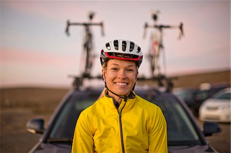 simsearch:6128-08738599,k - Portrait of a smiling young woman wearing a cycling helmet. Foto de stock - Royalty Free Premium, Número: 6128-08738596