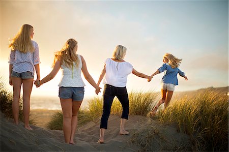 Teenage sisters holding hands with their mother on a beach. Foto de stock - Sin royalties Premium, Código: 6128-08738517