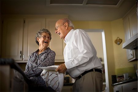 simsearch:614-03684753,k - Smiling elderly couple share an affectionate moment while they do the dishes together. Foto de stock - Sin royalties Premium, Código: 6128-08738627