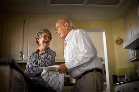 senior women kitchen - Smiling elderly couple share an affectionate moment while they do the dishes together. Foto de stock - Sin royalties Premium, Código: 6128-08738627