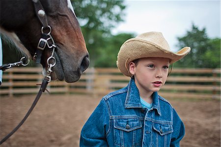 Young boy helping in the horse-training yard at a ranch. Stock Photo - Premium Royalty-Free, Code: 6128-08840979
