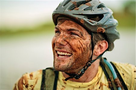 simsearch:6128-08738599,k - Happy young mountain biker laughing as he is covered in mud. Foto de stock - Royalty Free Premium, Número: 6128-08840992