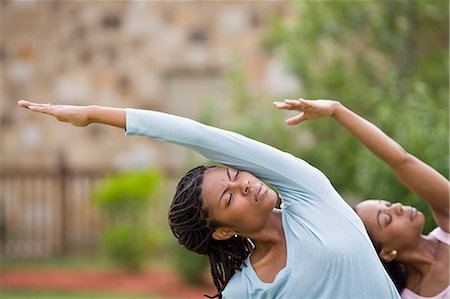 Two young woman doing yoga with their eyes closed. Stock Photo - Premium Royalty-Free, Code: 6128-08840997