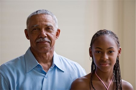 Portrait of a senior man standing next to his granddaughter. Stock Photo - Premium Royalty-Free, Code: 6128-08840994