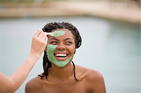 facial mask brush - Young woman with bare shoulders smiling while having a mud face mask applied. Stock Photo - Premium Royalty-Free, Code: 6128-08840998