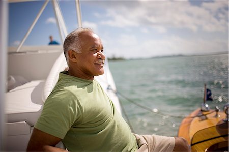 Smiling mature man sitting in his boat. Stock Photo - Premium Royalty-Free, Code: 6128-08840923