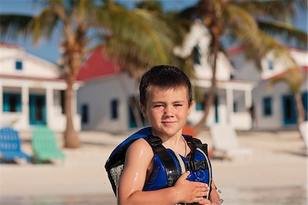 simsearch:400-06794010,k - Portrait of a young boy wearing a life vest while on a tropical beach. Stock Photo - Premium Royalty-Free, Code: 6128-08841048