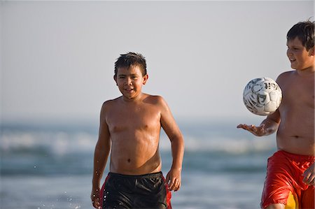 simsearch:400-04960671,k - Boys on the beach with a football Photographie de stock - Premium Libres de Droits, Code: 6128-08841028