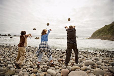 roca - Mature man with his teenage grandchildren throwing rocks into the sea. Photographie de stock - Premium Libres de Droits, Code: 6128-08825442