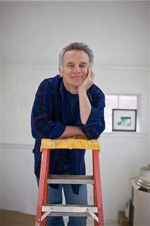 simsearch:693-03707681,k - Portrait of a mature man leaning on a ladder with his chin in his hand. Foto de stock - Royalty Free Premium, Número: 6128-08825463