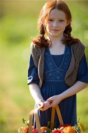 Portrait of a young girl holding a basket while on a farm. Stock Photo - Premium Royalty-Free, Code: 6128-08825404