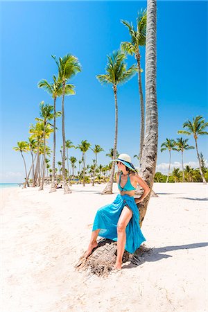 simsearch:6129-09044556,k - Juanillo Beach (playa Juanillo), Punta Cana, Dominican Republic. Woman relaxing on a palm-fringed beach (MR). Photographie de stock - Premium Libres de Droits, Code: 6129-09044549