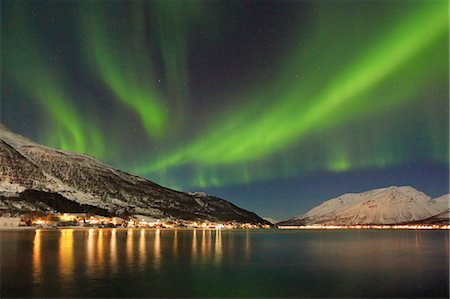 The Northern Lights is reflected in the icy sea surrounded by snowy peaks Manndalen Kafjord Lyngen Alps Tromsø Norway Europe Photographie de stock - Premium Libres de Droits, Code: 6129-09044810