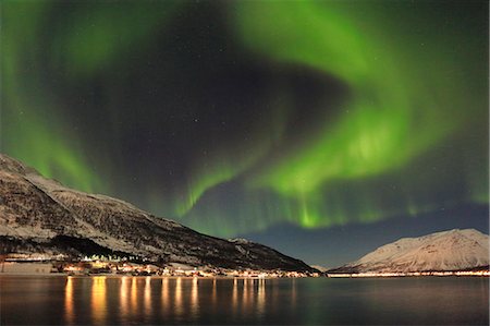 The Northern Lights is reflected in the icy sea surrounded by snowy peaks Manndalen Kafjord Lyngen Alps Tromsø Norway Europe Photographie de stock - Premium Libres de Droits, Code: 6129-09044811