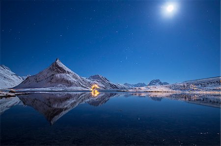 Full moon and stars light up the snow capped peaks reflected in sea Volanstinden Fredvang Lofoten Islands Northern Norway Europe Foto de stock - Sin royalties Premium, Código: 6129-09044838