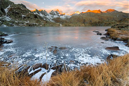 simsearch:400-04961475,k - Italy, Trentino Alto Adige, Adamello Brenta Park, Nambrone valley, Dawn at Black Lake, in background Presanella group sunlit. Foto de stock - Sin royalties Premium, Código: 6129-09057639