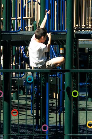 Rear view of a boy clambering on jungle gym Stock Photo - Premium Royalty-Free, Code: 625-00805134