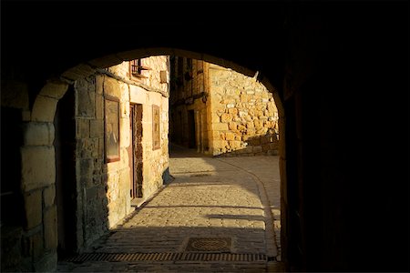 dark alleyway - Arched gateway leading to a cobblestone alley, Spain Stock Photo - Premium Royalty-Free, Code: 625-00805800