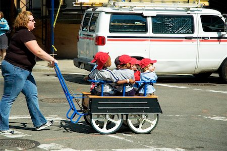 Mid adult woman pushing children in a trolley Stock Photo - Premium Royalty-Free, Code: 625-00806047