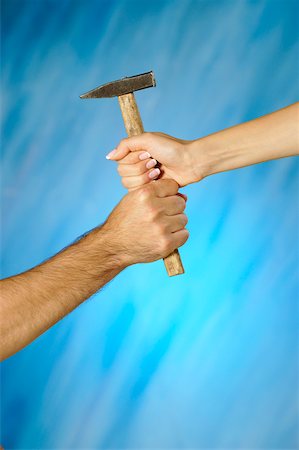 Close-up of a man and a woman's hands holding a hammer Stock Photo - Premium Royalty-Free, Code: 625-00802519