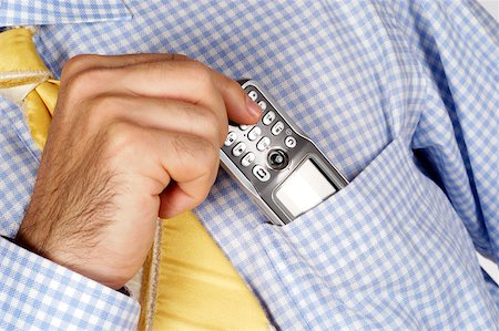Mid section view of a businessman putting a mobile phone into his shirt pocket Stock Photo - Premium Royalty-Free, Code: 625-00802592