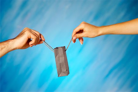 Close-up of a man and a woman's hands holding a shopping bag Stock Photo - Premium Royalty-Free, Code: 625-00802647