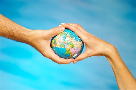 Close-up of a man and a woman's hands holding a globe Stock Photo - Premium Royalty-Free, Code: 625-00802736