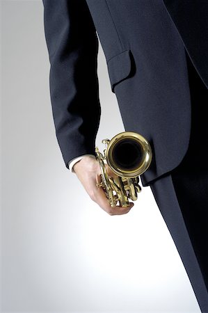 simsearch:625-00802645,k - Mid section view of a man holding a trumpet Fotografie stock - Premium Royalty-Free, Codice: 625-00802768
