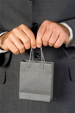 Mid section view of a businessman holding a shopping bag Stock Photo - Premium Royalty-Free, Code: 625-00802794