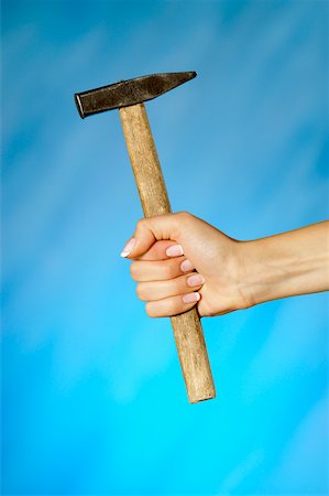 Close-up of a woman's hand holding a hammer Stock Photo - Premium Royalty-Free, Code: 625-00802818