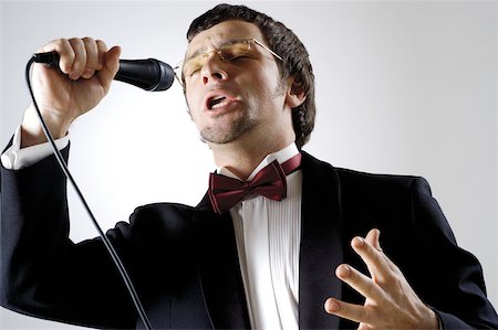 Close-up of a young man singing into a microphone Stock Photo - Premium Royalty-Free, Code: 625-00802842