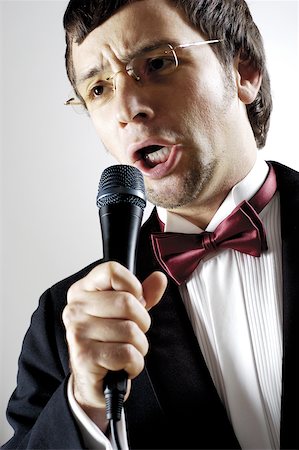 Close-up of a young man singing into a microphone Stock Photo - Premium Royalty-Free, Code: 625-00802875