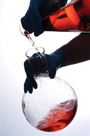 Close-up of a person pouring chemicals into a beaker Stock Photo - Premium Royalty-Free, Code: 625-00835993