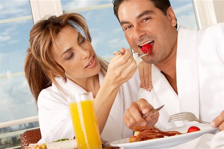 full breakfast - Close-up of a mid adult woman feeding a strawberry to a mid adult man Stock Photo - Premium Royalty-Free, Code: 625-00837610