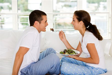 schoolchild eat - Side profile of a young woman feeding a young man salad Stock Photo - Premium Royalty-Free, Code: 625-00837626