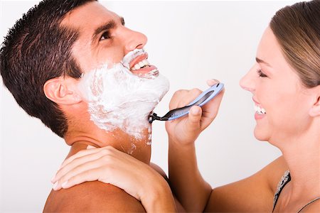 shaving man woman - Side profile of a young woman shaving a mid adult man Stock Photo - Premium Royalty-Free, Code: 625-00837643