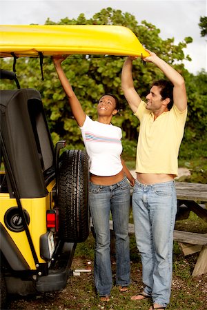 Young woman and a mid adult man loading a kayak on a jeep Stock Photo - Premium Royalty-Free, Code: 625-00837667