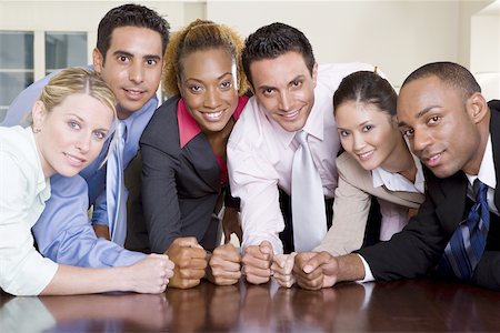 portrait of a group of clerks - Portrait of a group of business executives pounding their fists on a conference table Stock Photo - Premium Royalty-Free, Code: 625-00837845